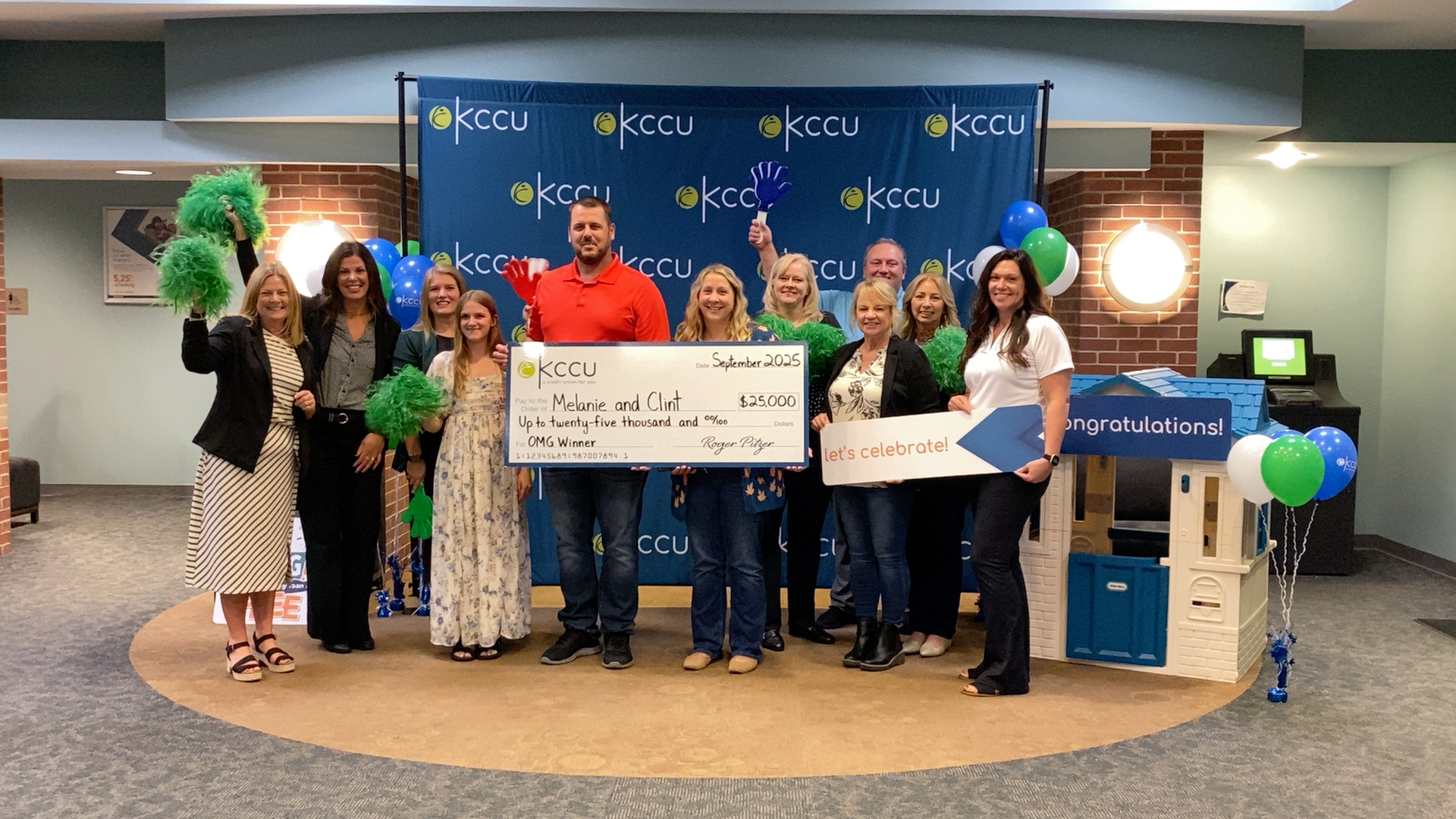 Clint and Melanie holding check with KCCU Team Members